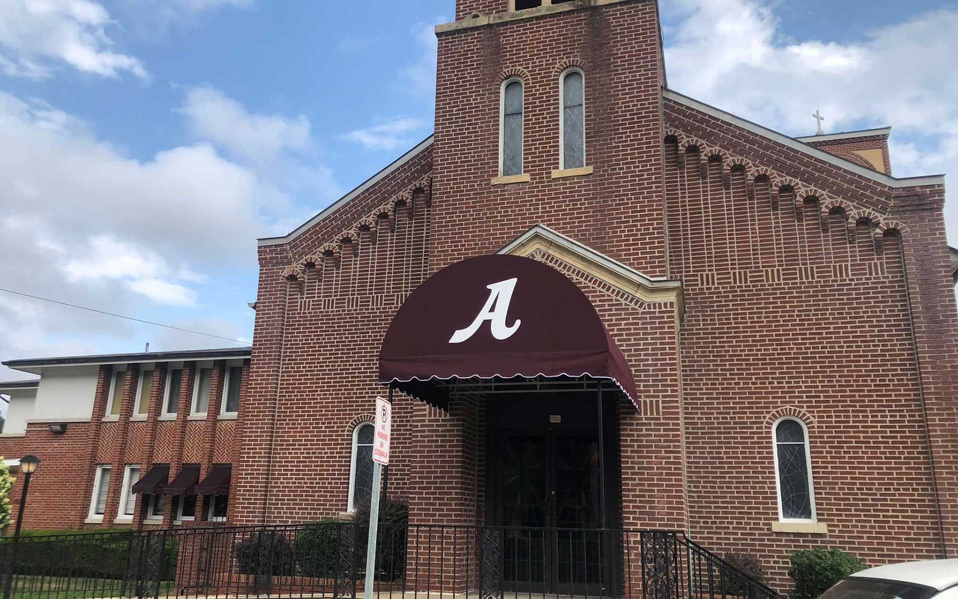A brick building with a red awning with the letter a on it