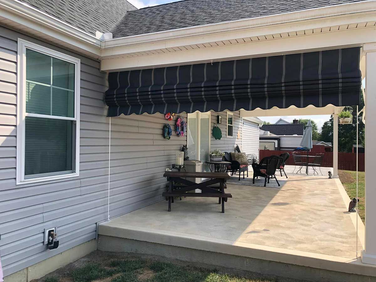 A patio with a canopy over it and a picnic table and chairs.