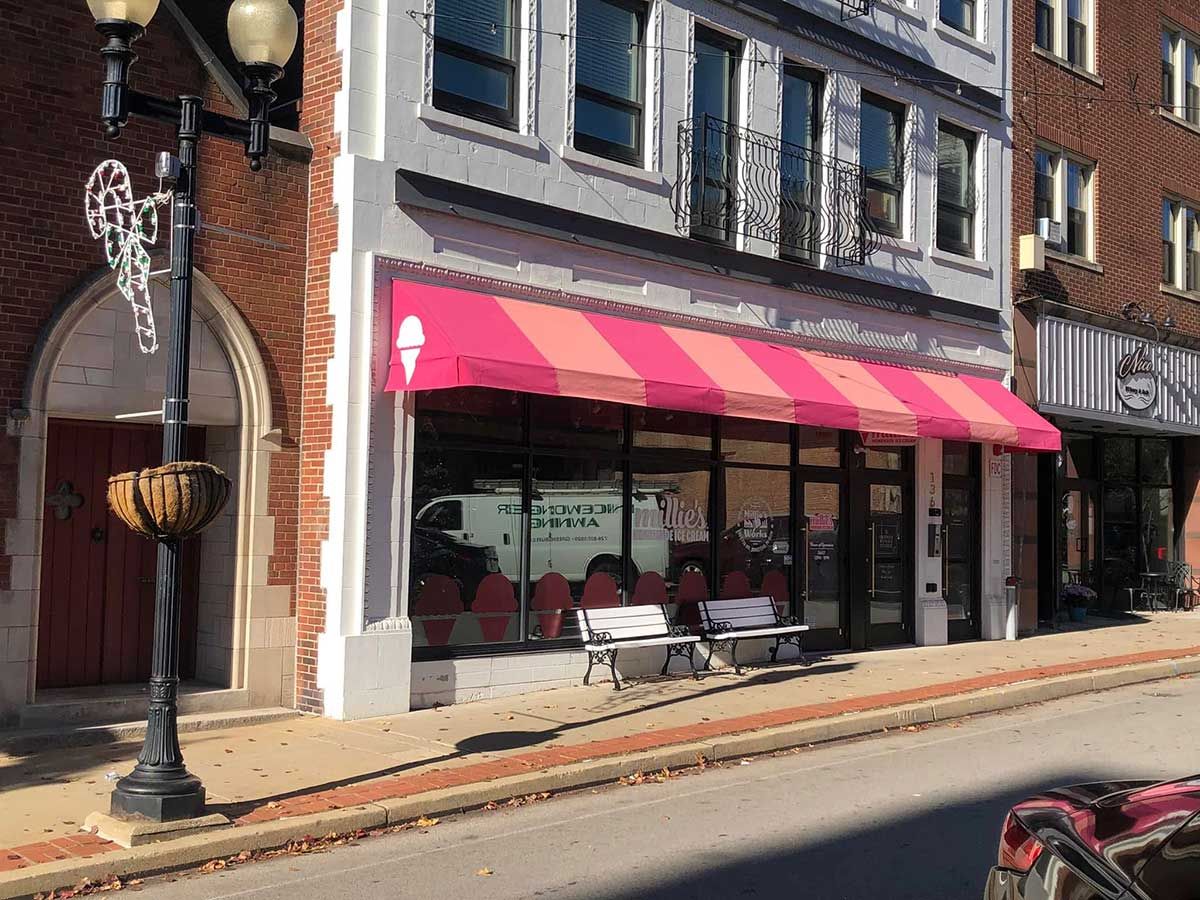 A pink awning is on the side of a building.