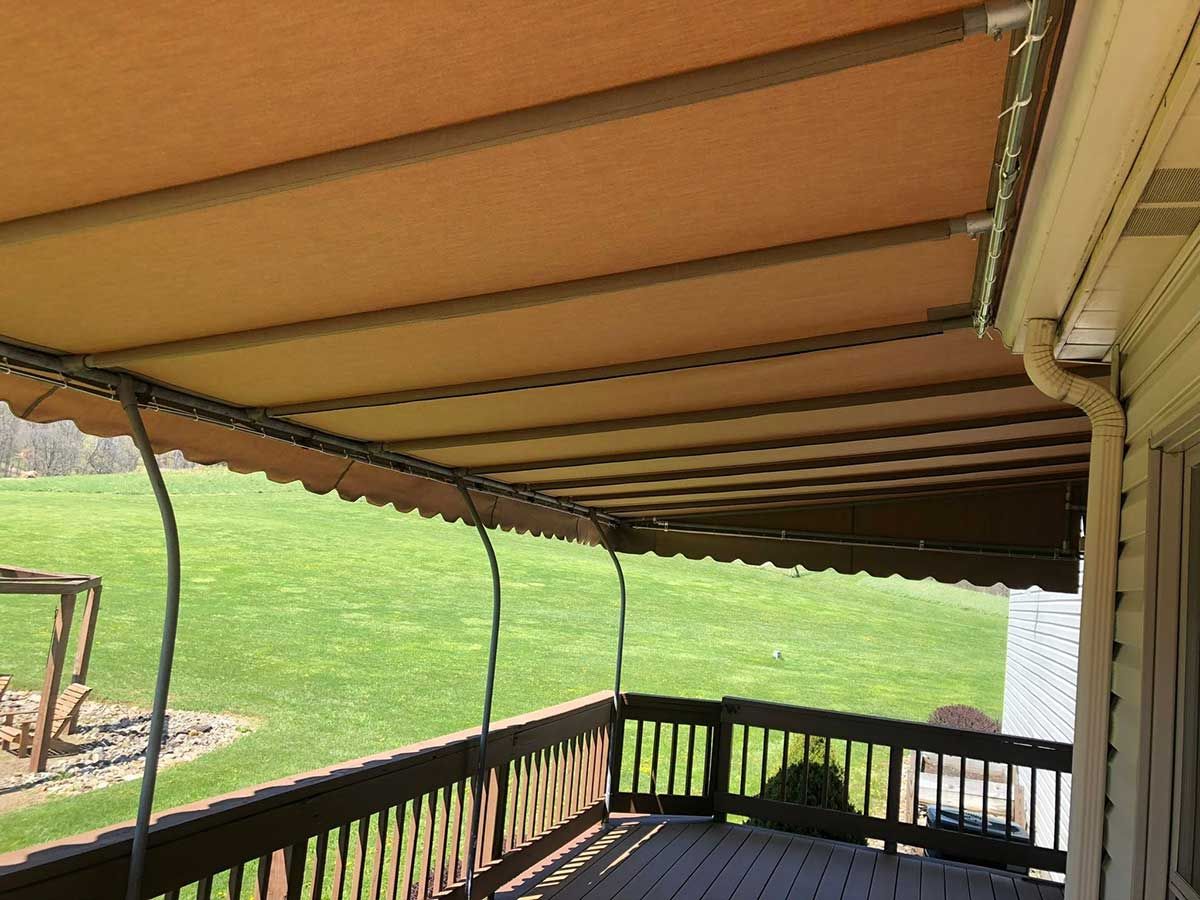 A deck with a canopy over it and a lawn in the background.