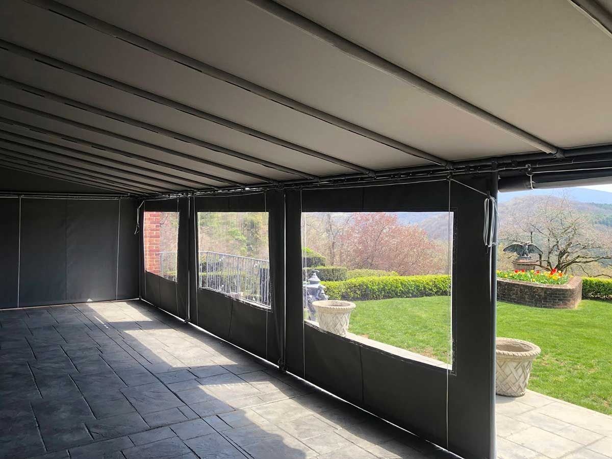 A large patio with a lot of windows and a view of a garden.