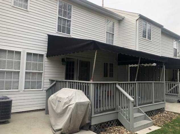 A house with a porch and a grill on it.