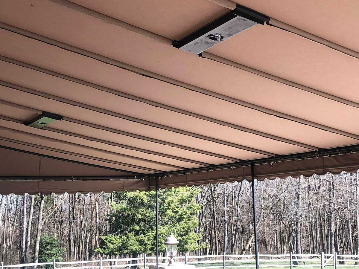 The ceiling of a covered area with trees in the background.