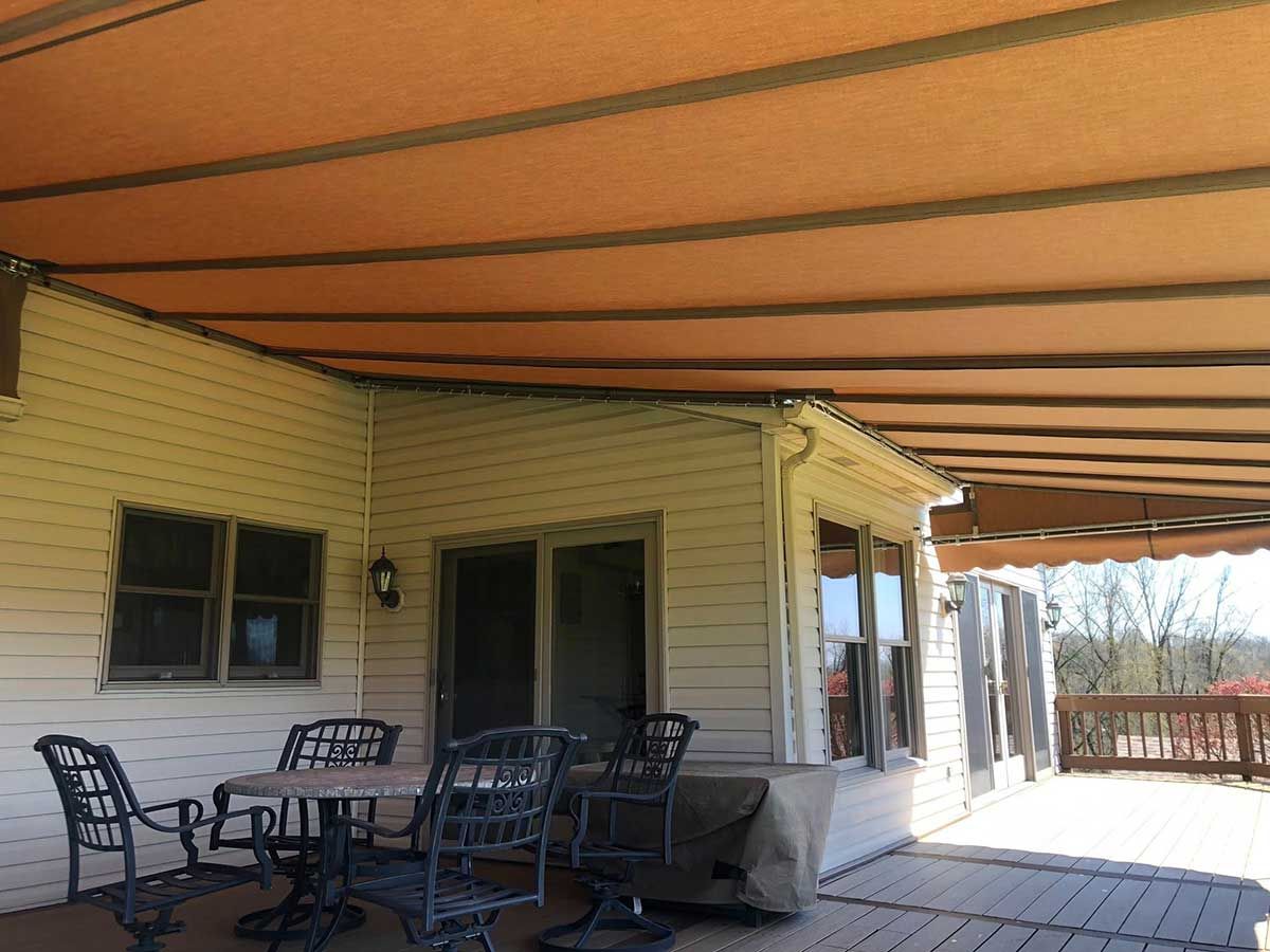 A patio with a table and chairs under an awning.