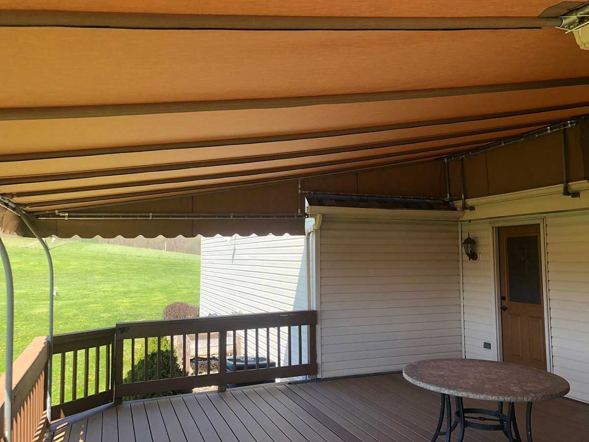 A deck with a table and a canopy over it.