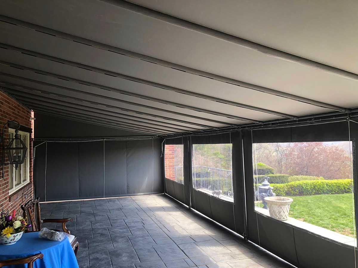 A patio with a table and chairs under a canopy.