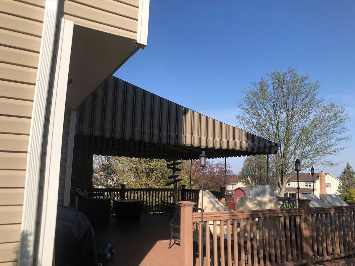 A house with a striped awning on the side of it