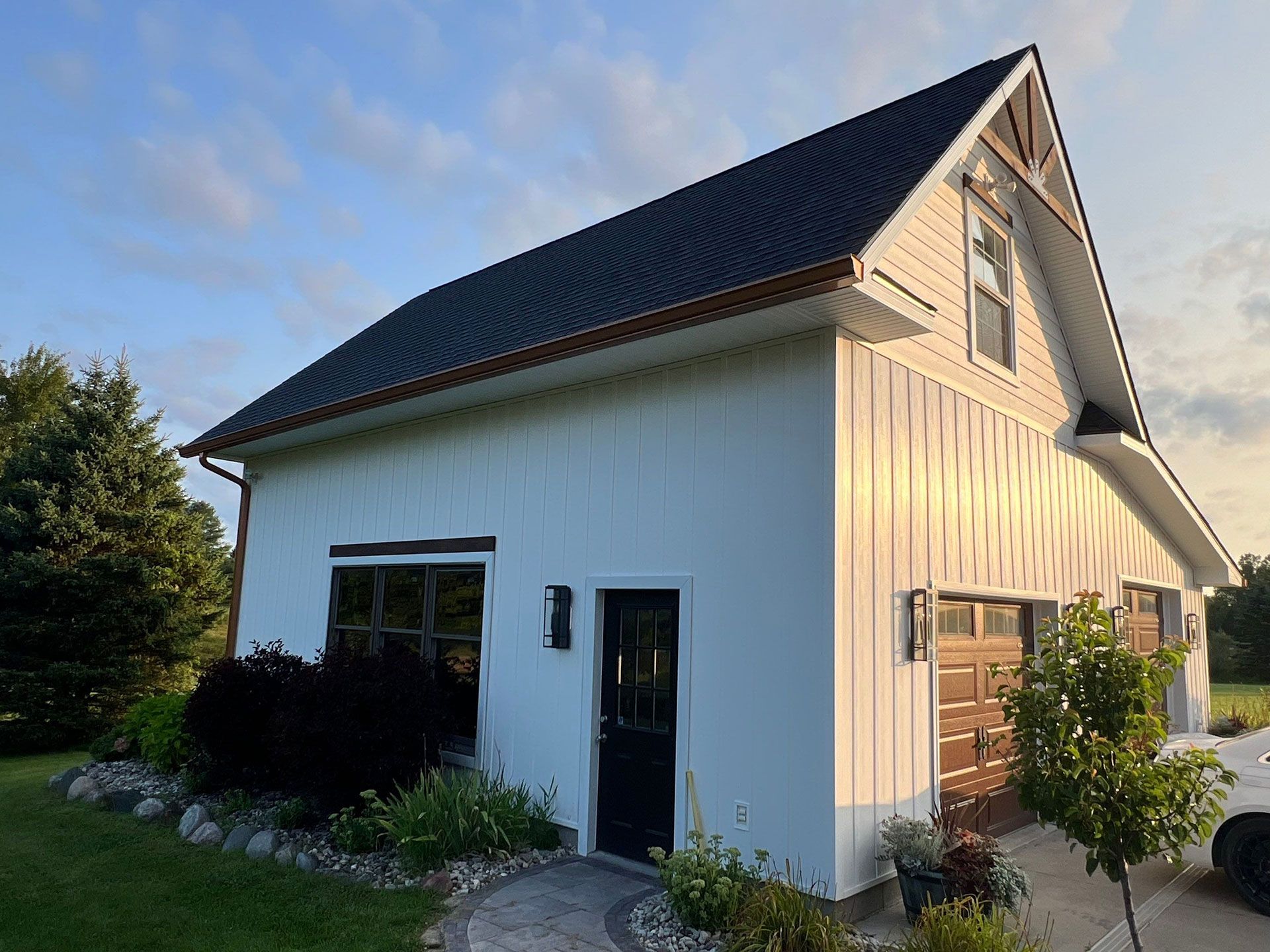 A white house with a black roof and a black door