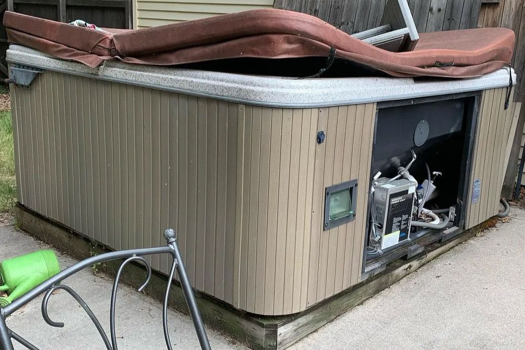 A large hot tub is sitting on top of a wooden deck