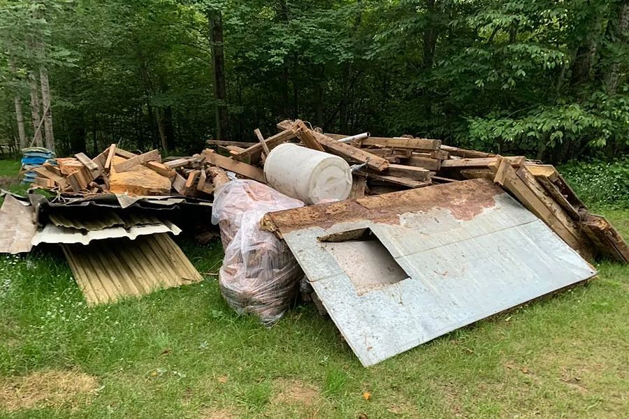 Learn More About Junk Curbside Pick-Up A pile of wood and metal is sitting on top of a lush green field