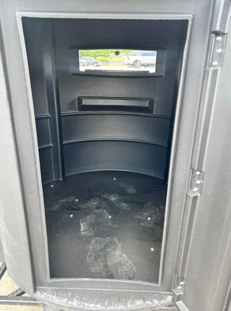 The inside of a portable toilet with the door open.