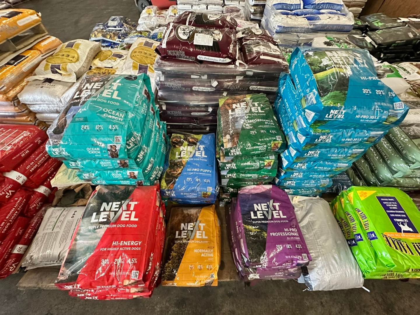 A bunch of bags of dog food are stacked on top of each other.