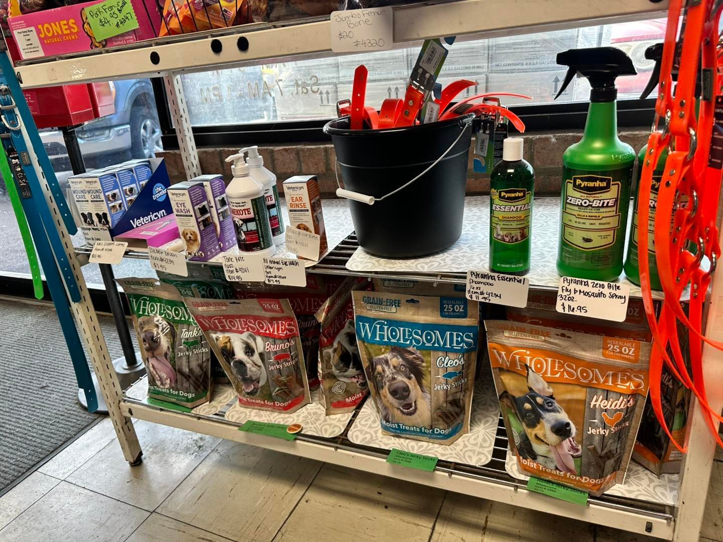 A shelf filled with lots of dog food and supplies in a store.