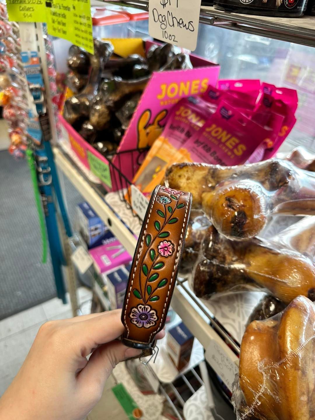 A person is holding a dog collar in a store.