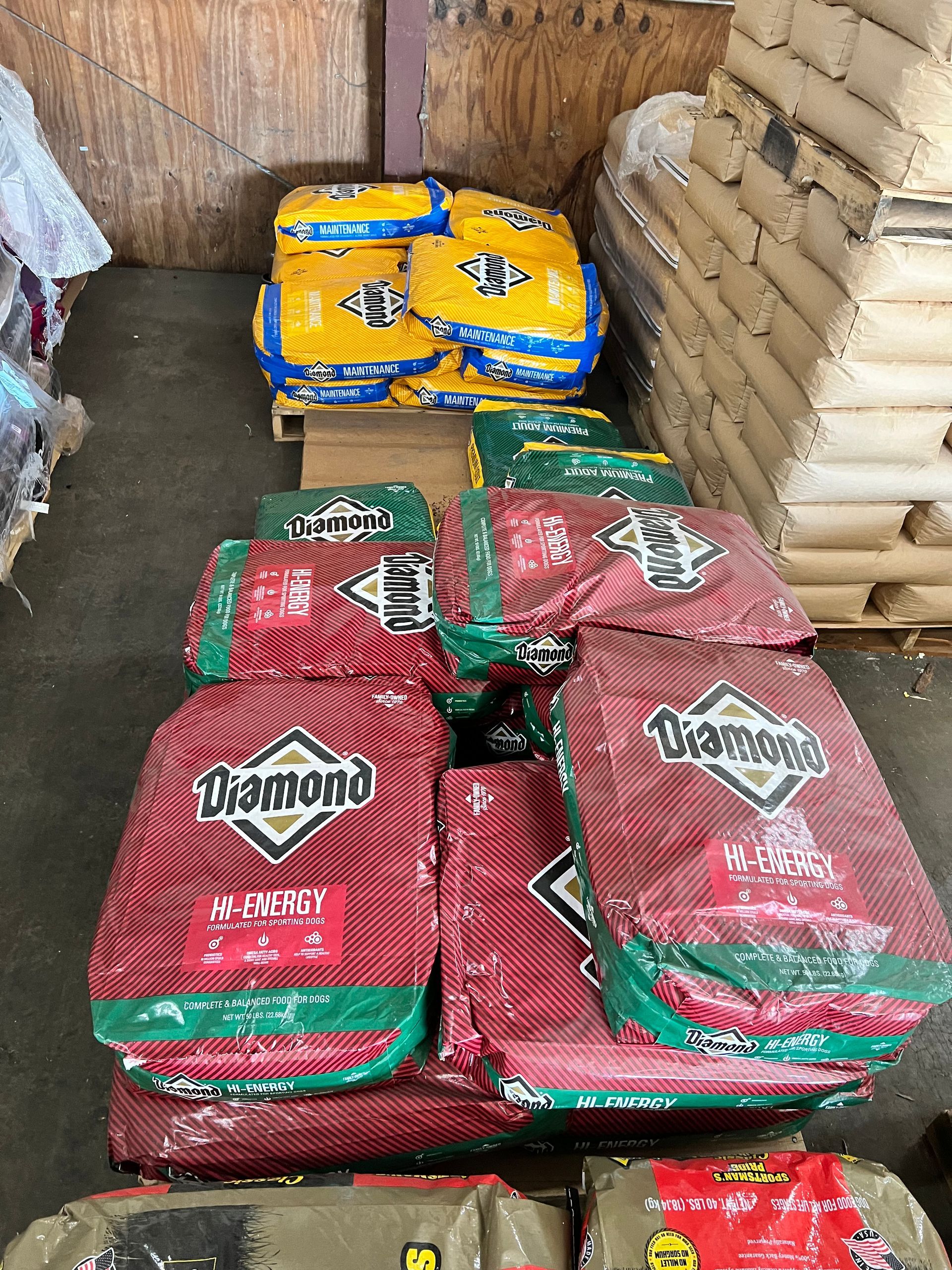 A bunch of bags of dog food are stacked on top of each other in a warehouse.