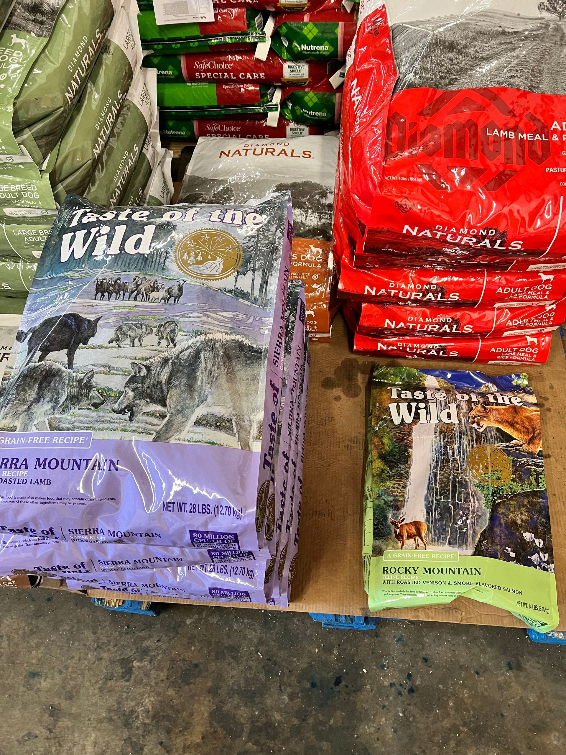 A bunch of bags of dog food are sitting on a table.