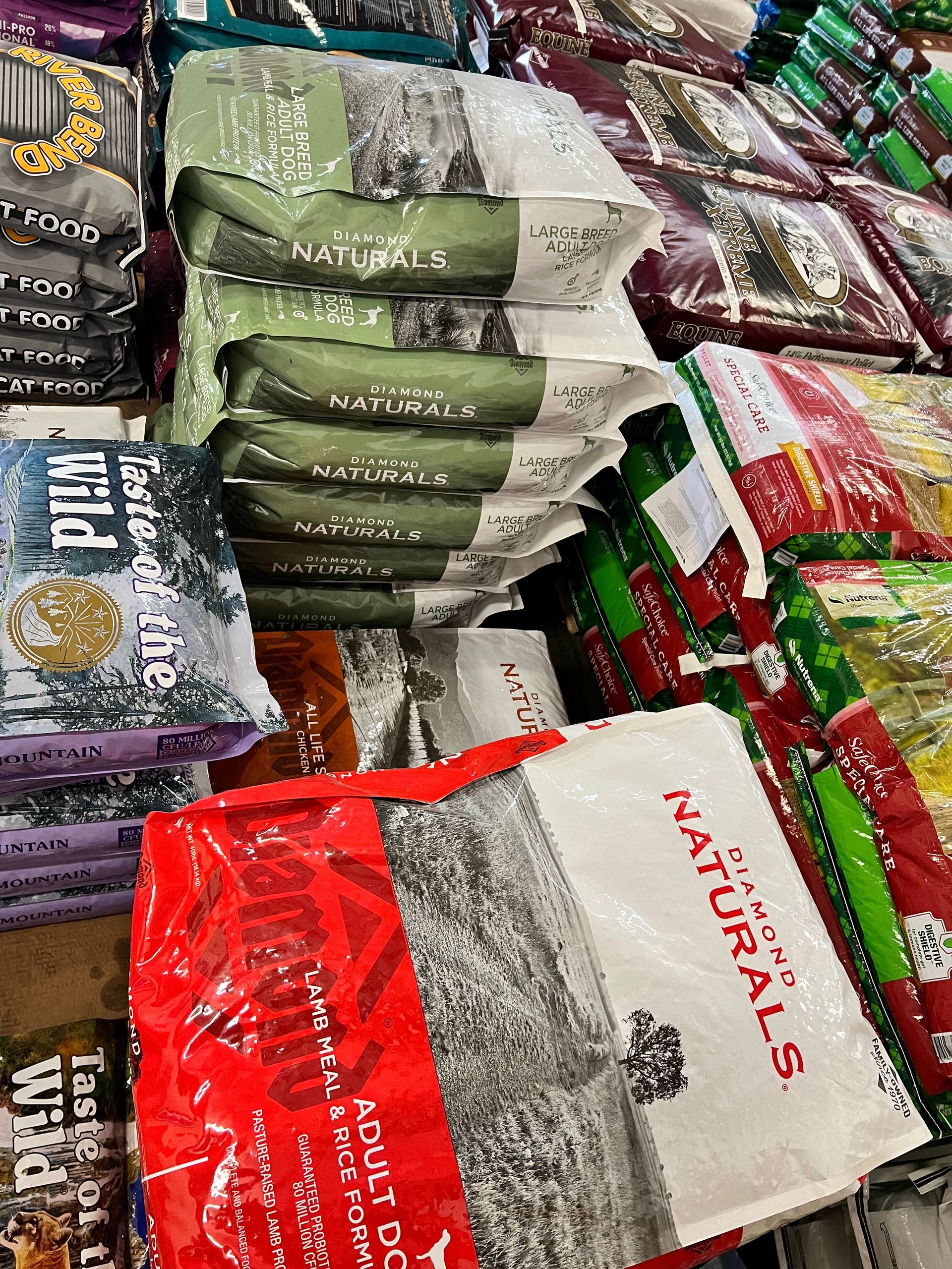 A bunch of bags of dog food are stacked on top of each other in a store.