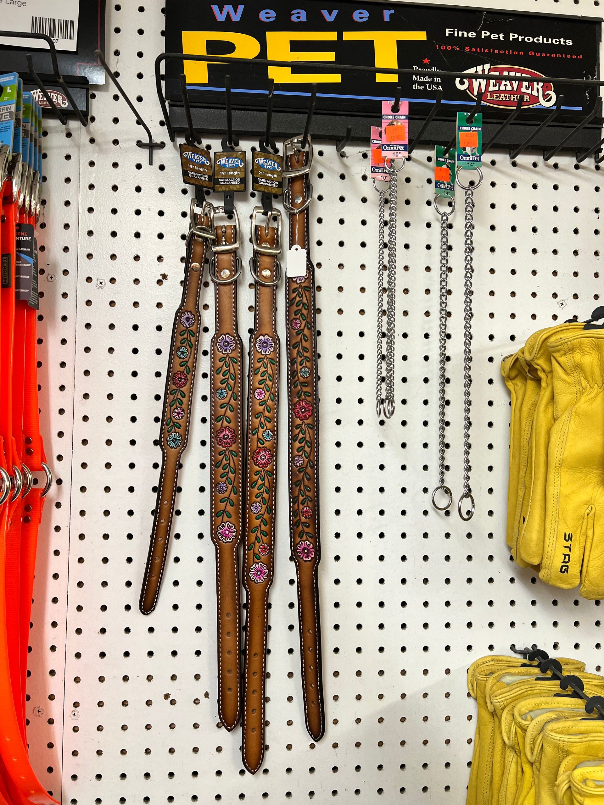 A bunch of dog collars hanging on a wall with a sign that says weaver pet