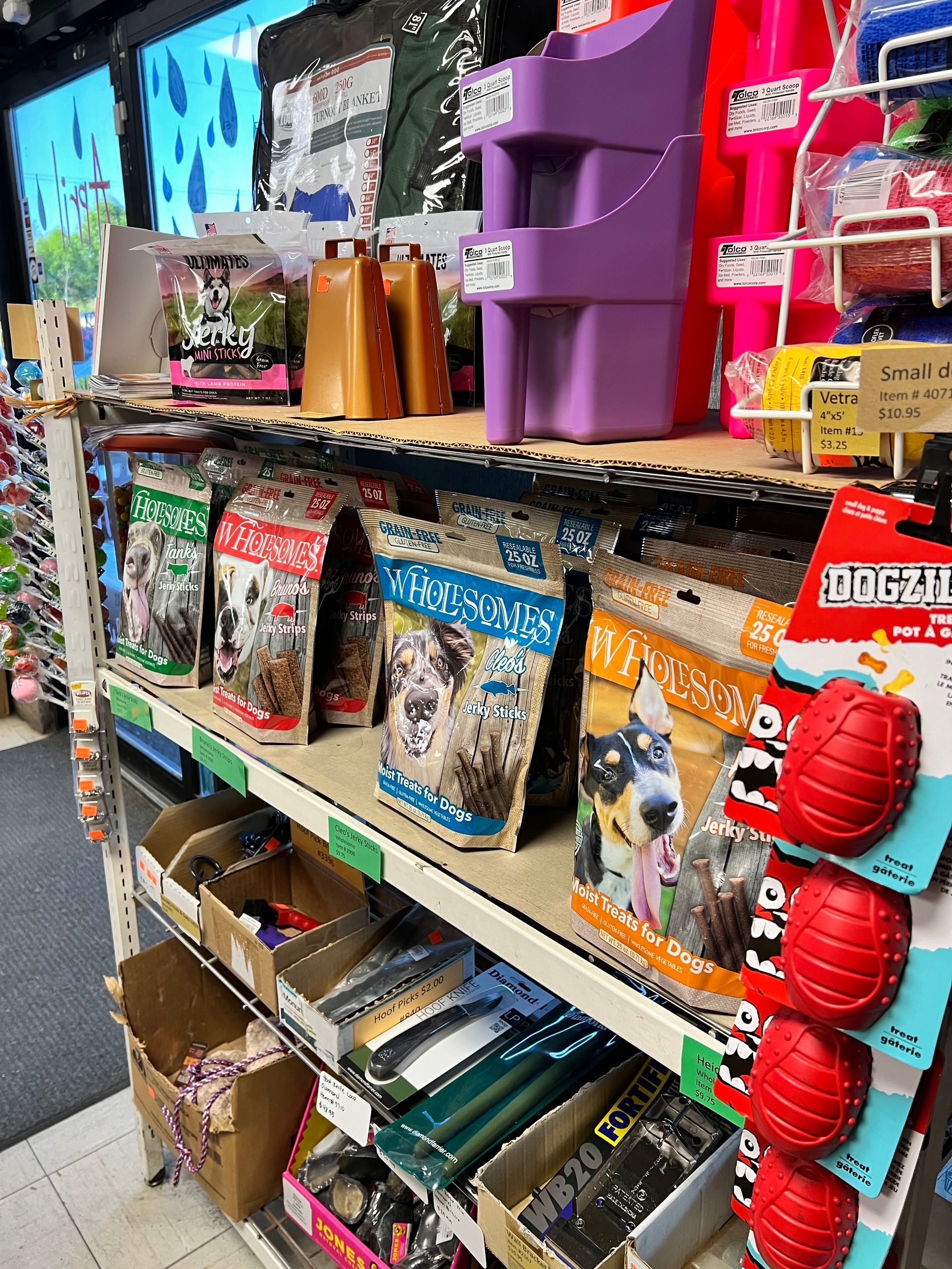 A shelf filled with bags of dog food and toys in a store.