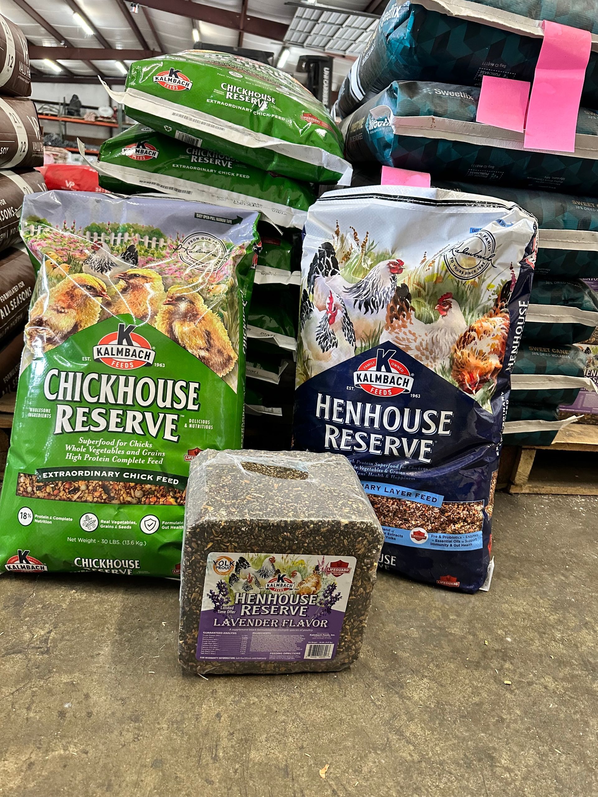 A warehouse filled with bags of chicken food and a block of hay.