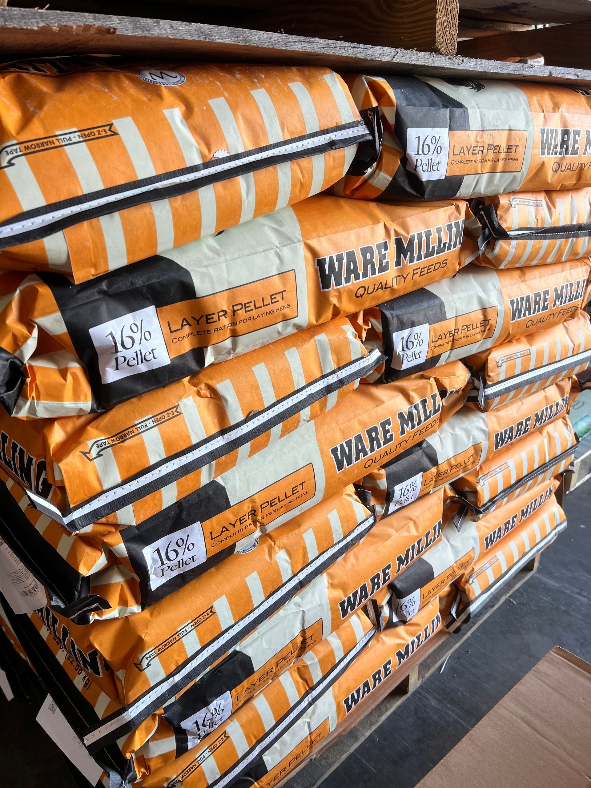 A stack of orange and white bags of ware mills