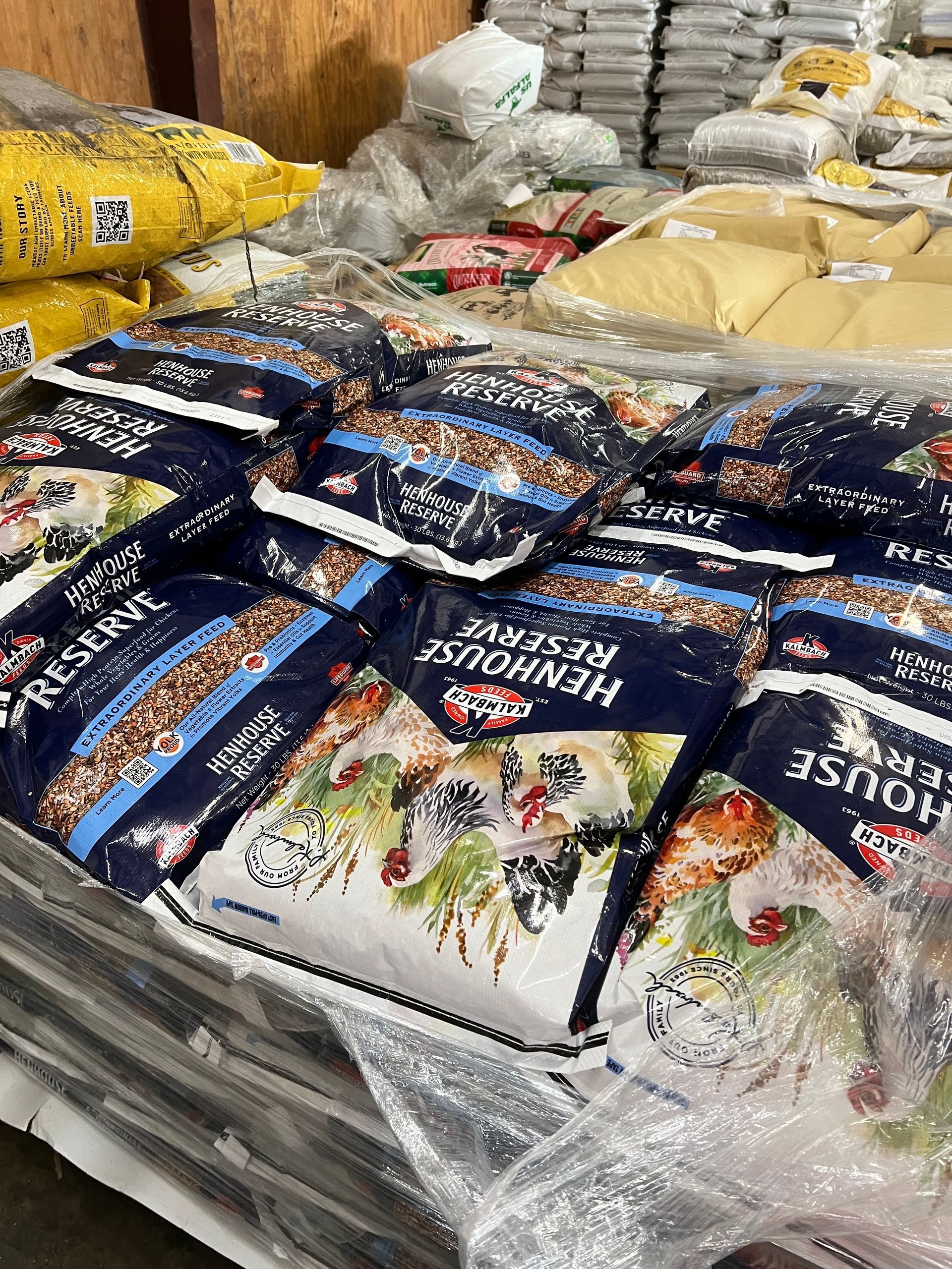 A bunch of bags of food are stacked on top of each other in a warehouse.