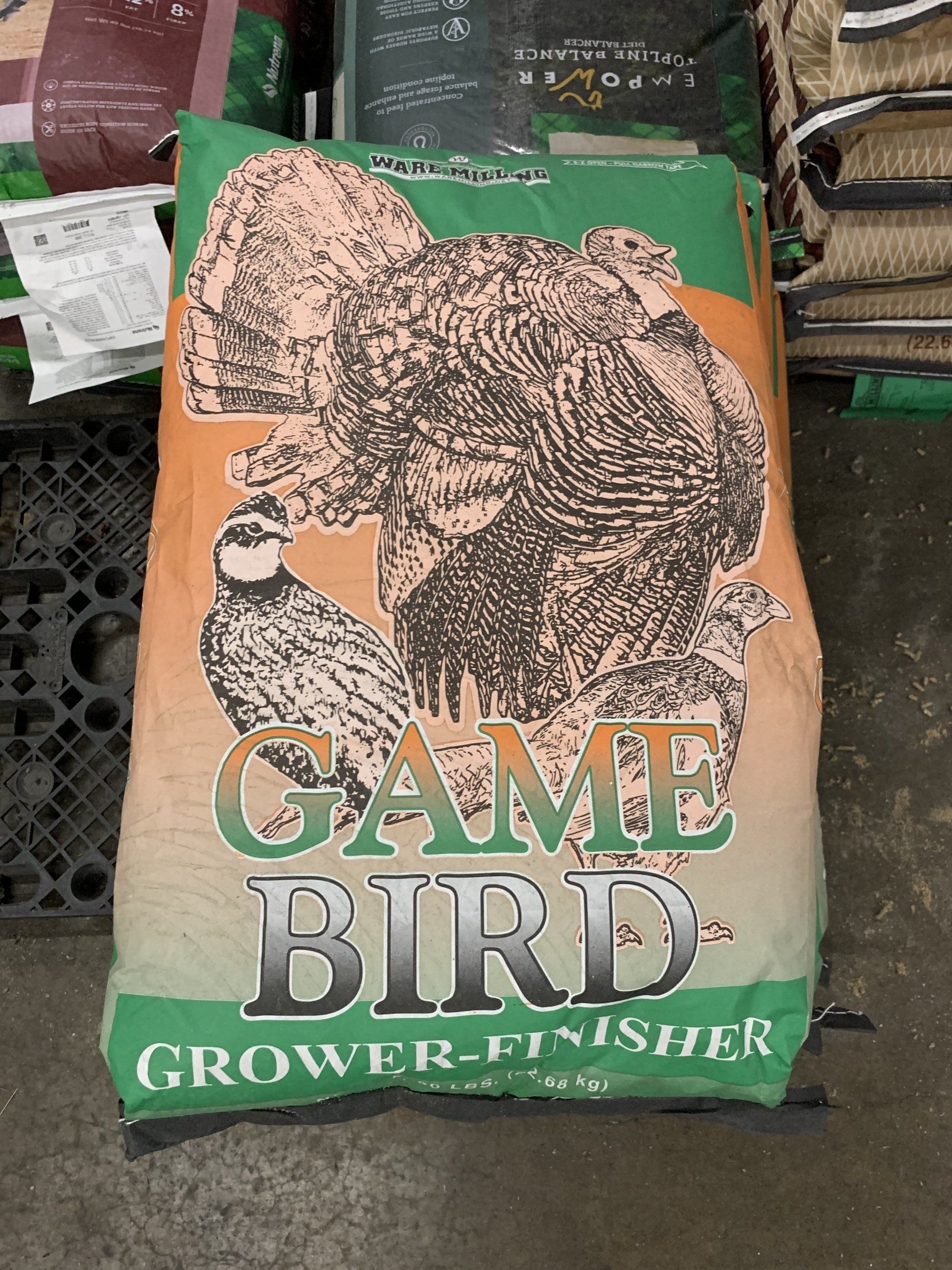 A bag of game bird grower fertilizer is sitting on the ground