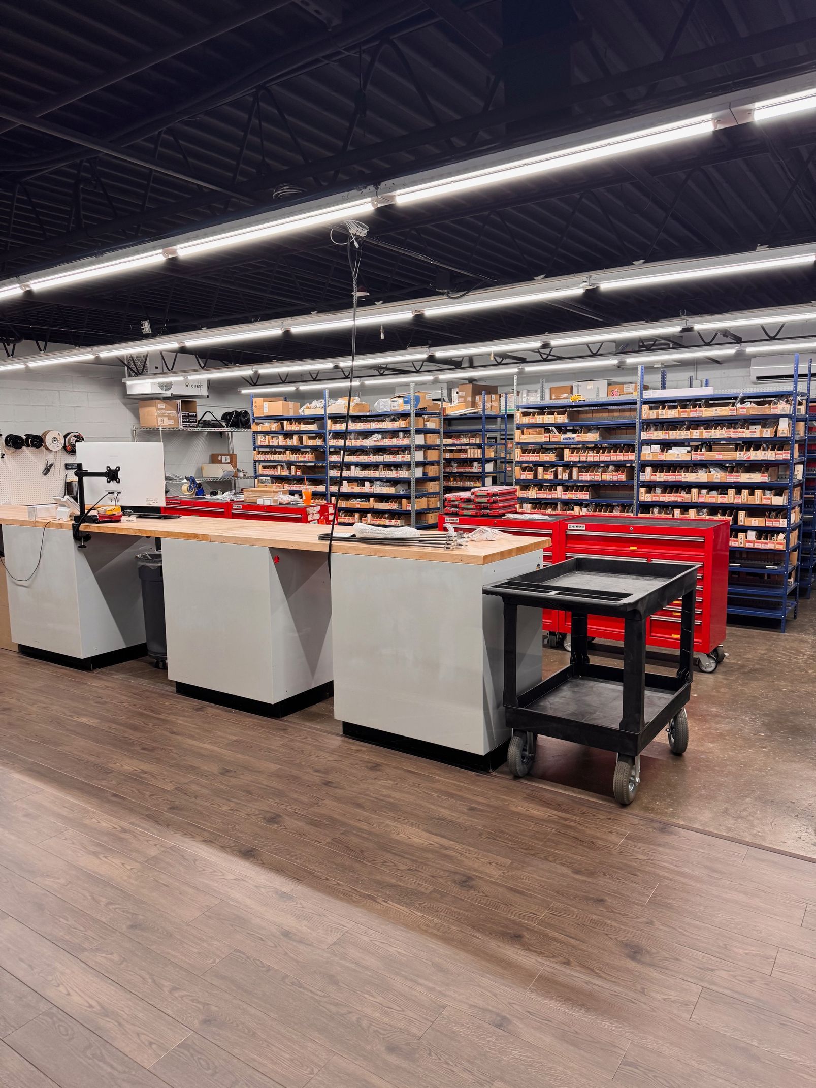Workshop interior with workbenches, tools, and shelves of parts.