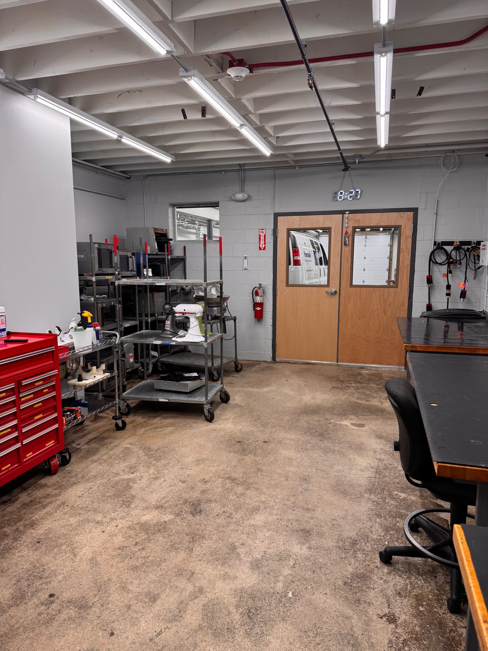 Garage workshop with tools, a red toolbox, and a door.