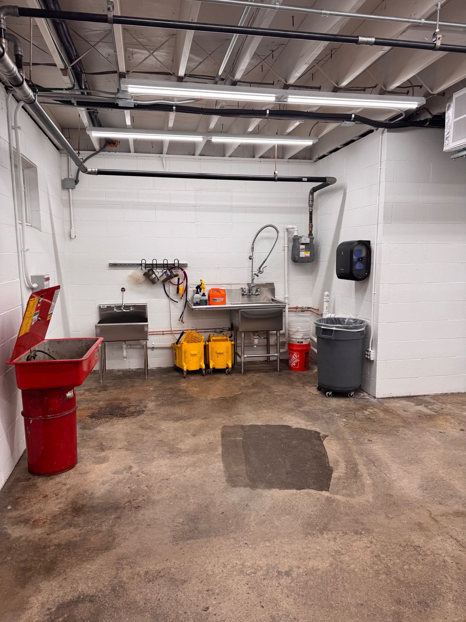 Workshop with sinks, waste bins, and equipment.