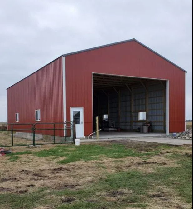 Person installing brown siding on the edge of a wooden structure.
