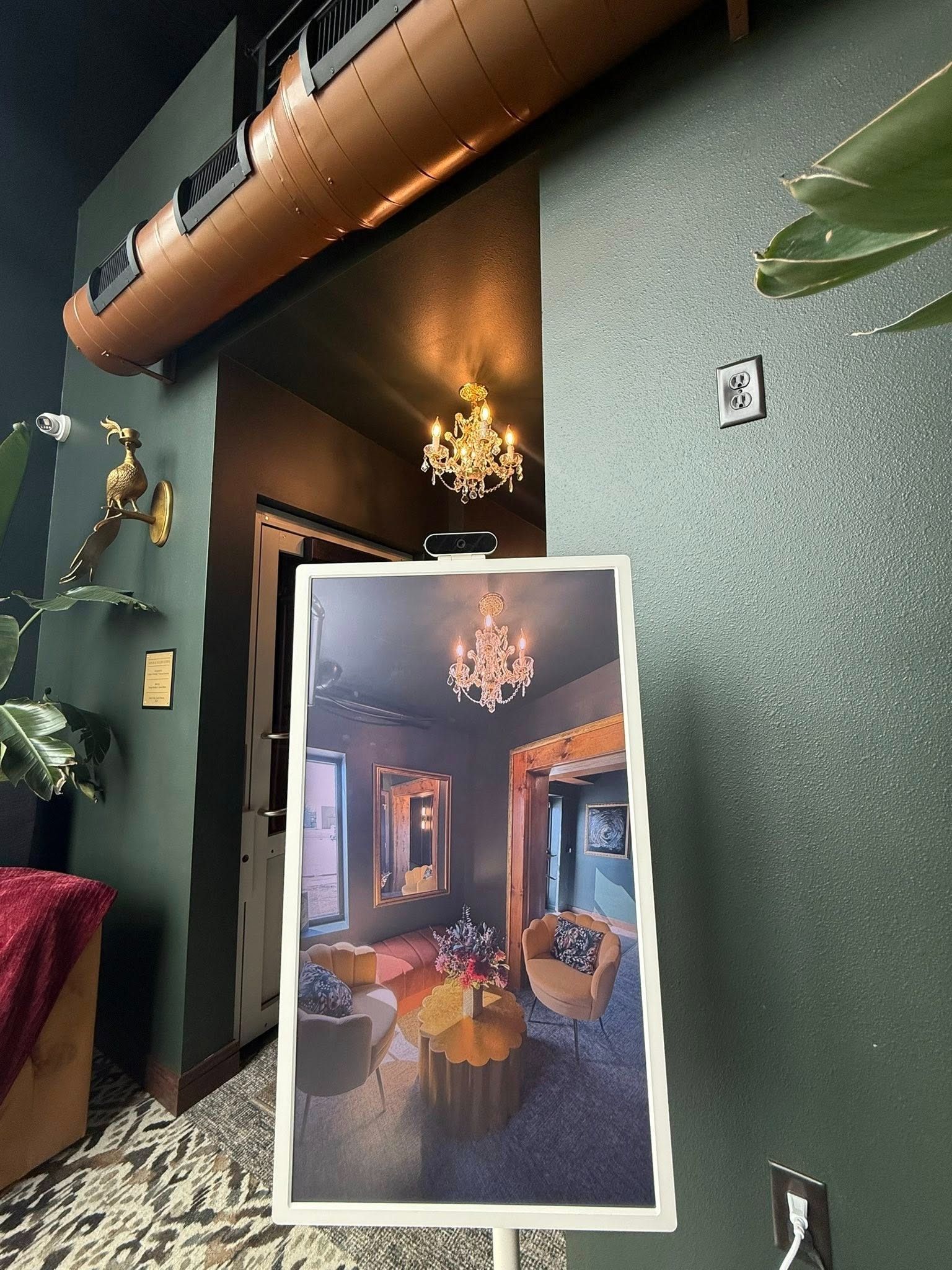 Interior wall with textured green finish and a poster showing a warmly lit room with chandelier.