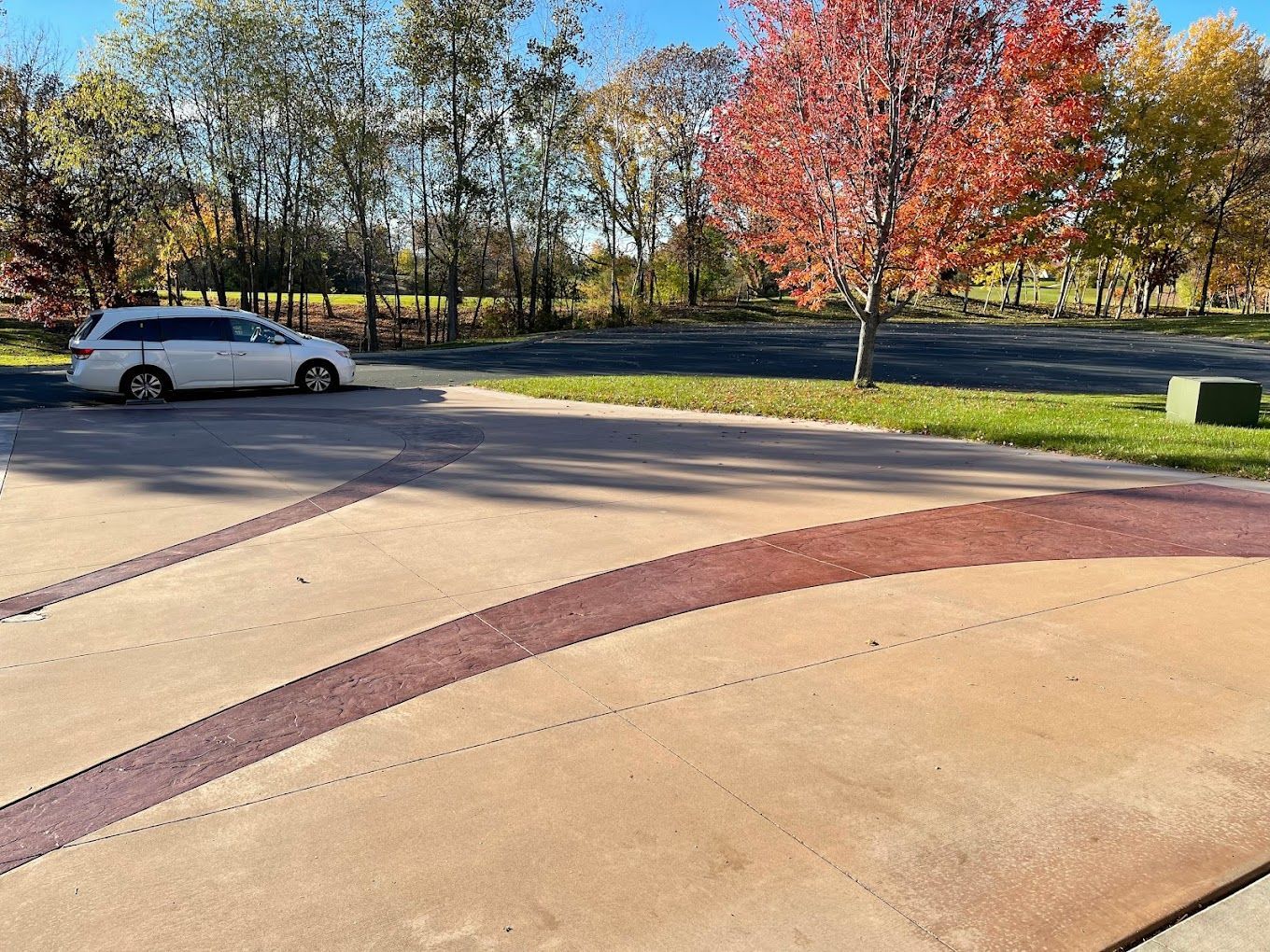 a white van is parked in a driveway next to a tree