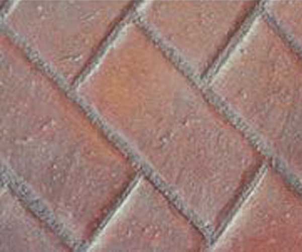 A close up of a brick floor with a diagonal pattern.