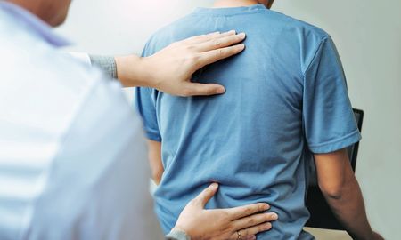 A man is getting his back examined by a doctor.