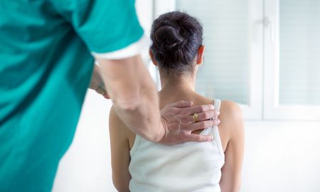 A woman is getting a massage from a doctor.