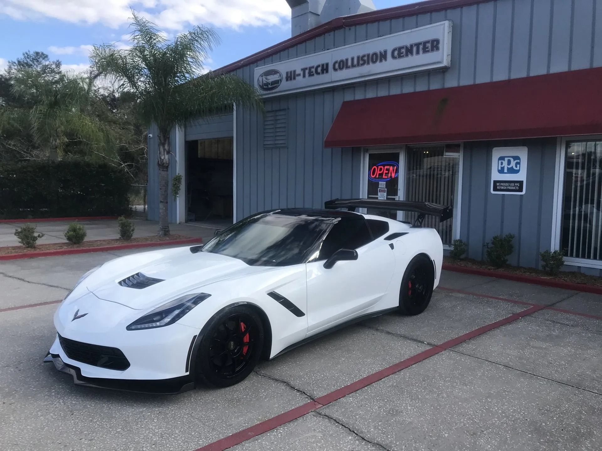 A white sports car is parked in front of a building.