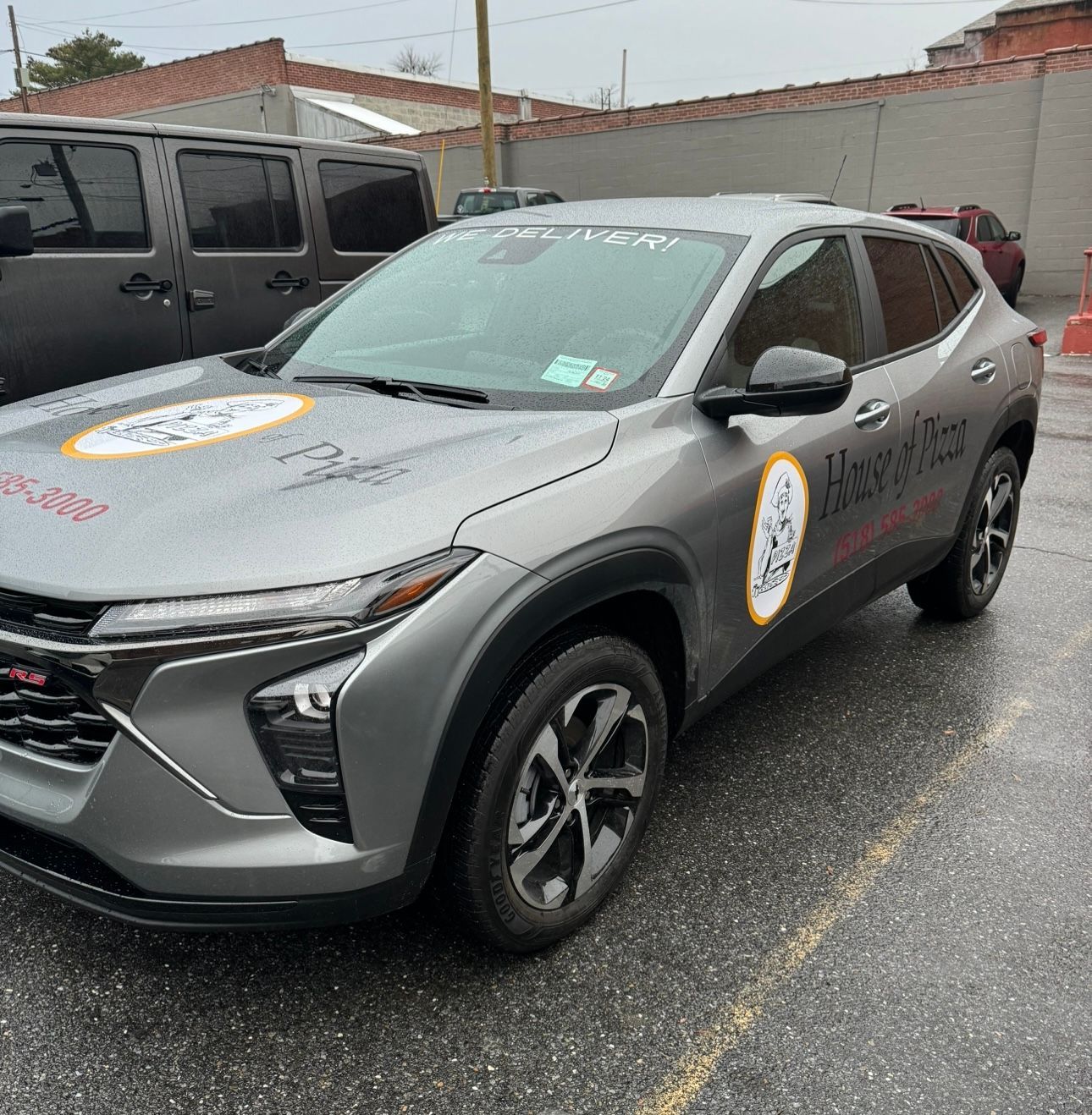 A gray car is parked in a parking lot.