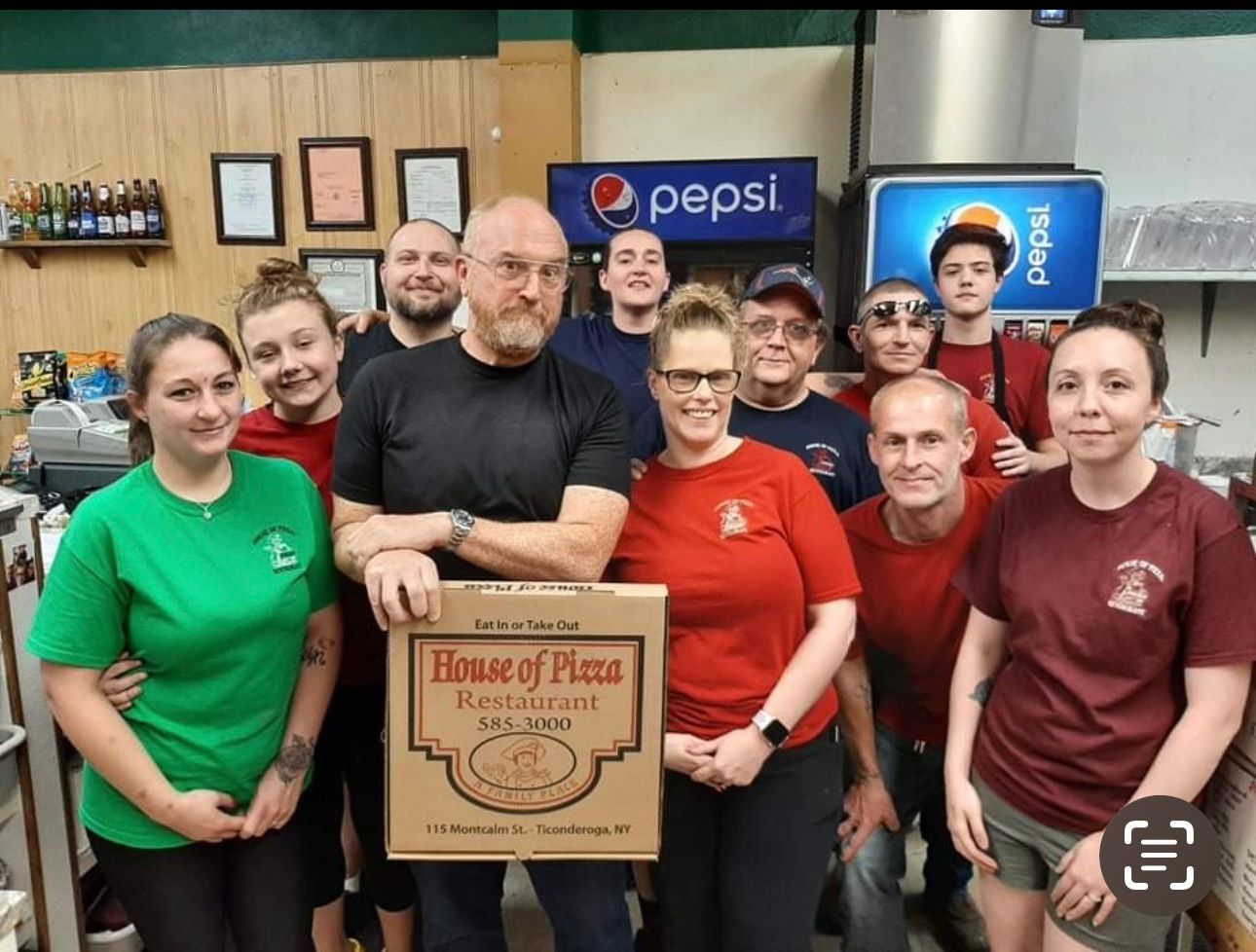A group of people standing in front of a pepsi sign
