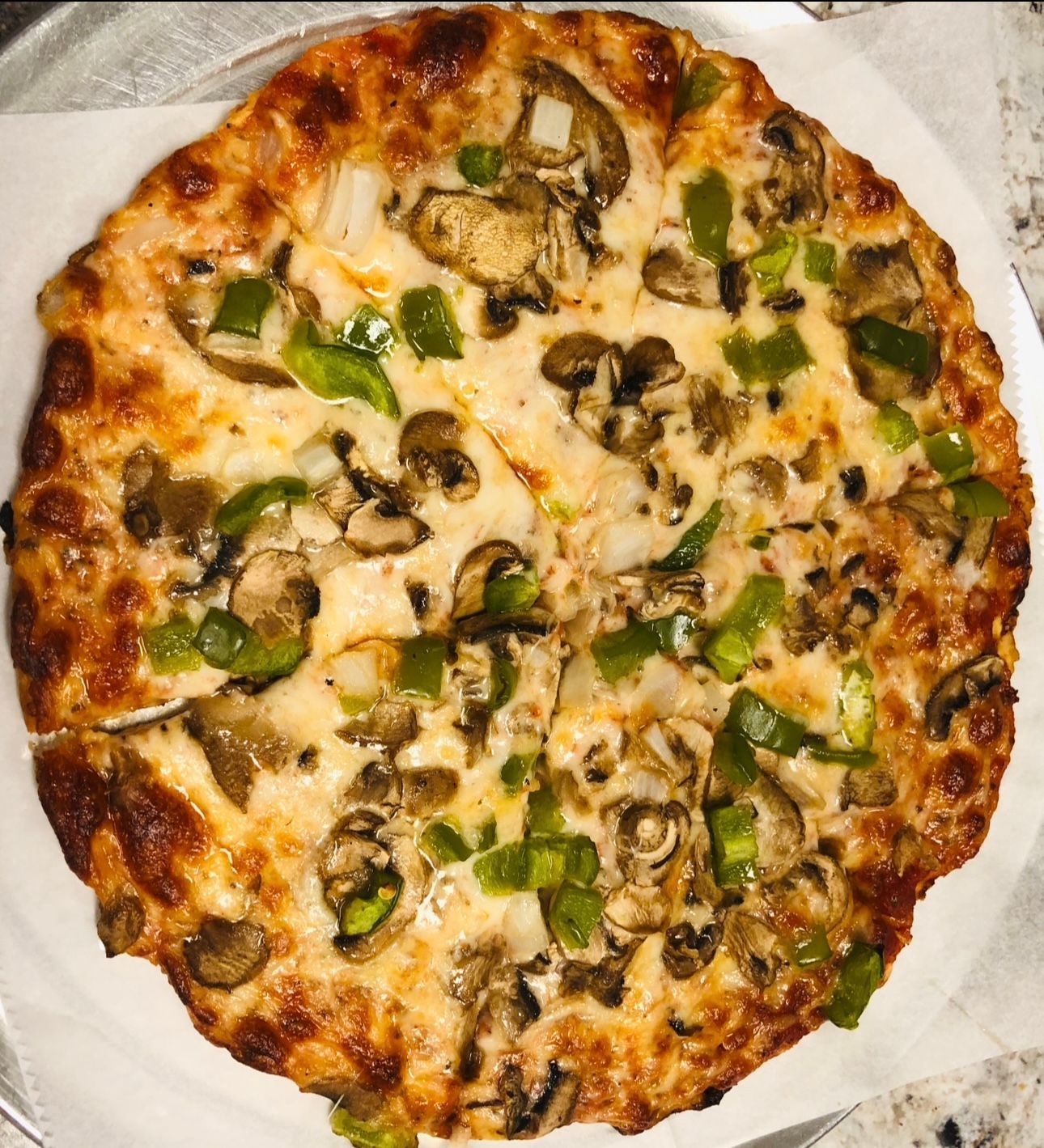 A pizza with mushrooms and green peppers on it
