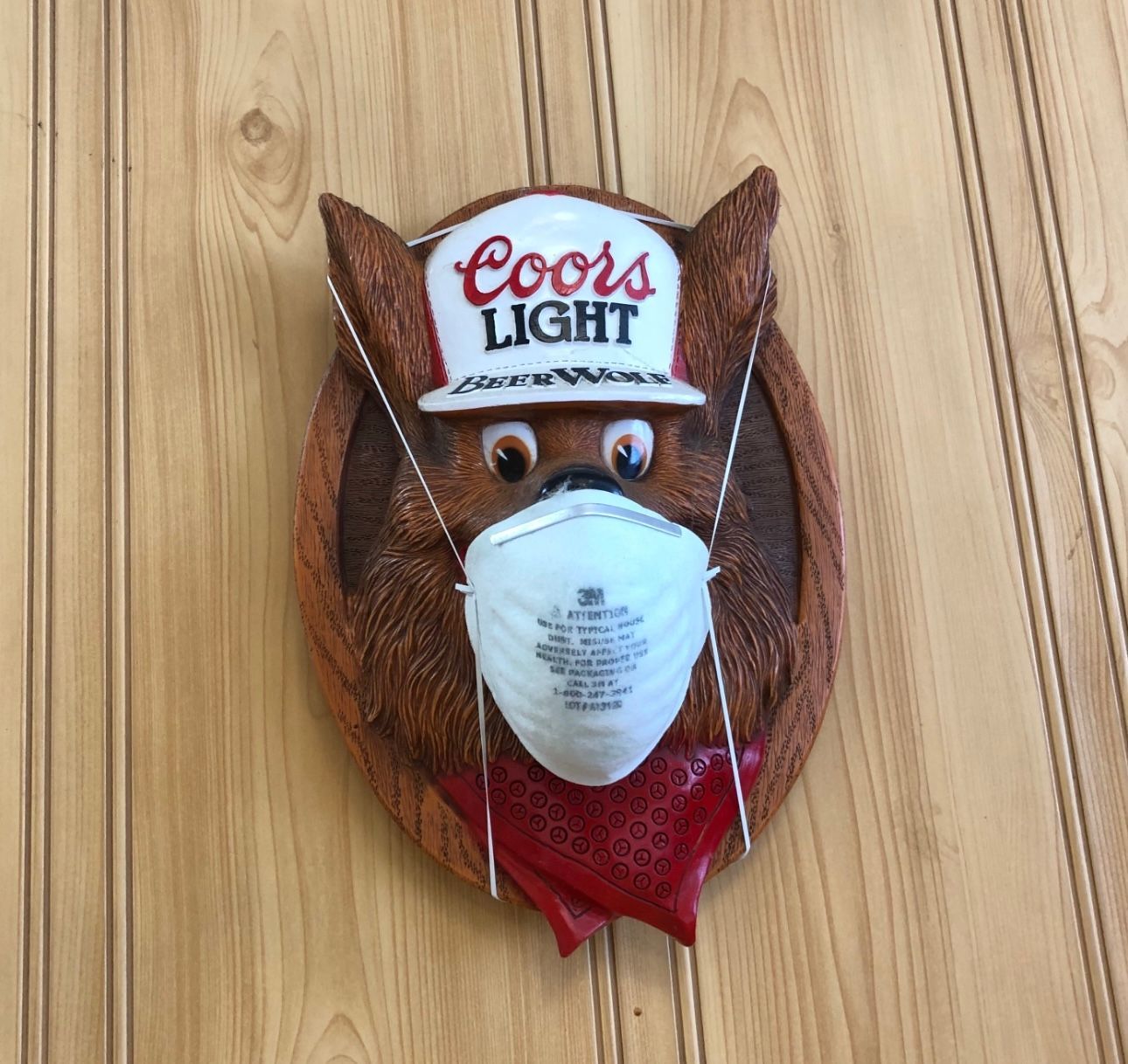 A bear wearing a coors light hat and mask