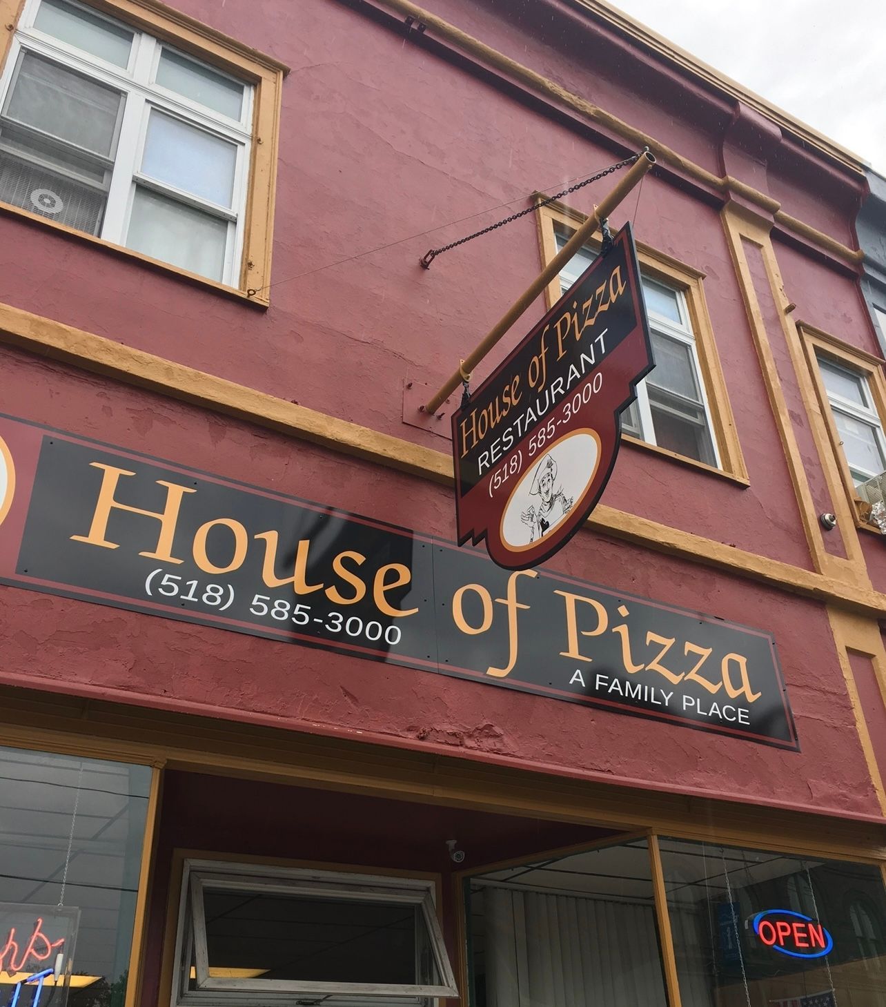 A building with a sign that says house of pizza