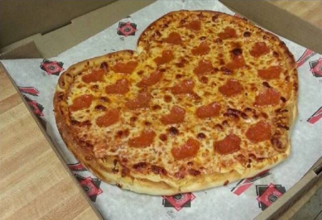 A heart shaped pepperoni pizza in a box