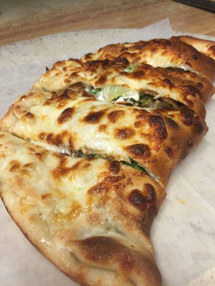 A close up of a pizza sitting on top of a table.