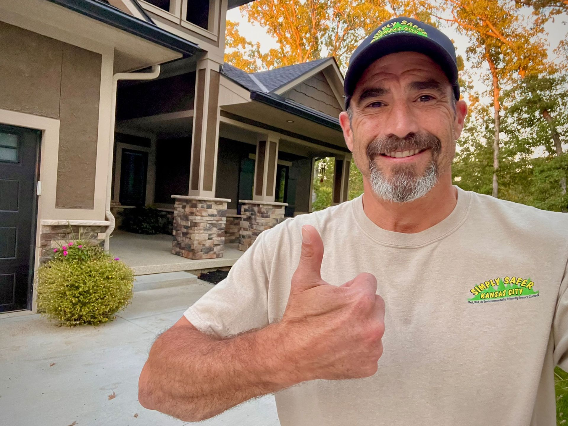 a man is giving a thumbs up in front of a house