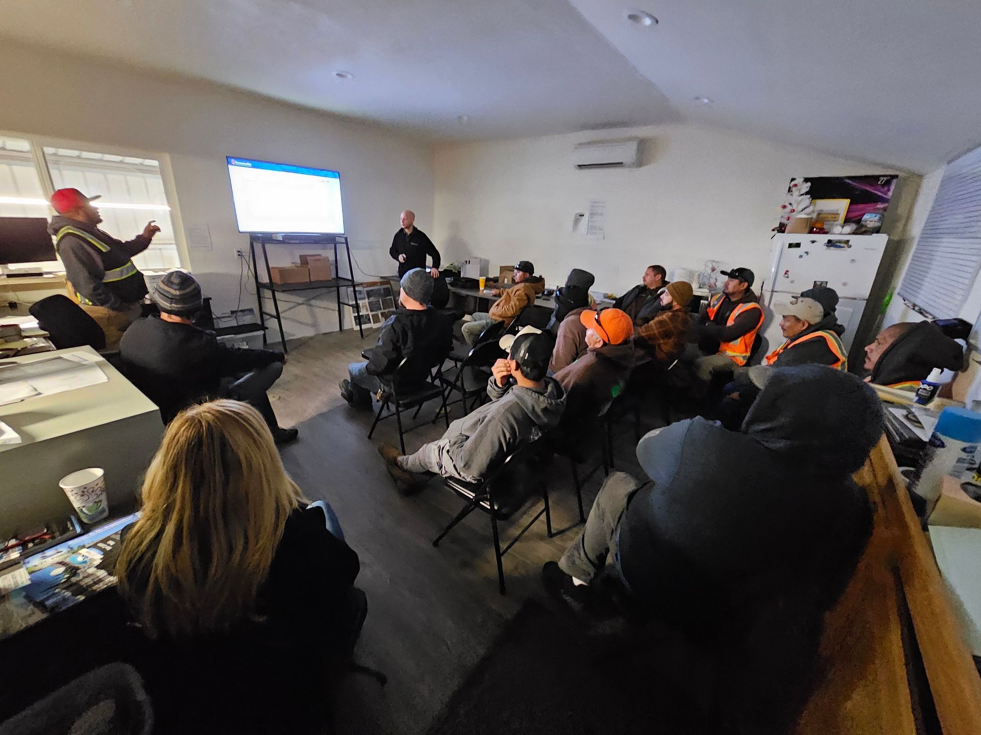 A group of people are sitting in a room watching a presentation