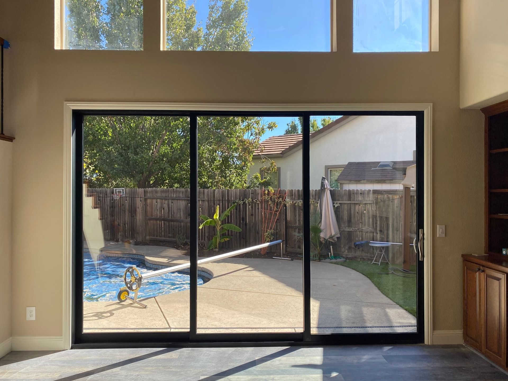 A living room with a sliding glass door leading to a pool.