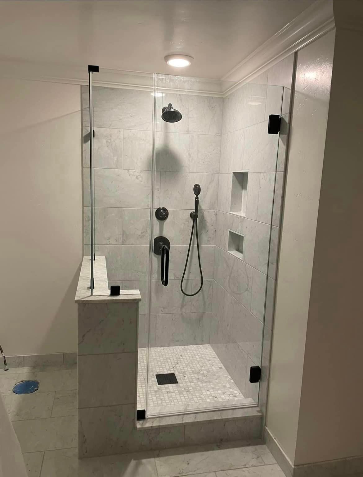 A bathroom with a walk in shower with a glass door.