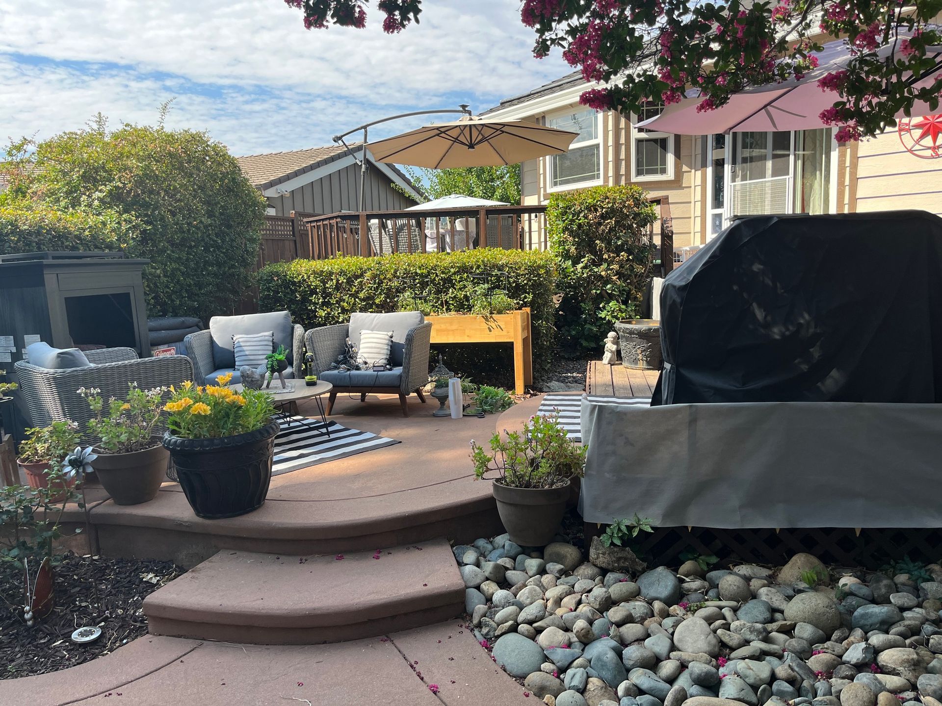 A patio with a grill and umbrella in the backyard