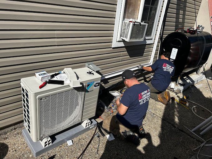 Two men are working on an air conditioner outside of a house.